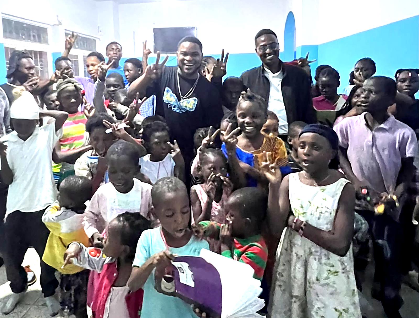 Enfants et équipe de VISION lors d'une distribution de fournitures dans un orphelinat